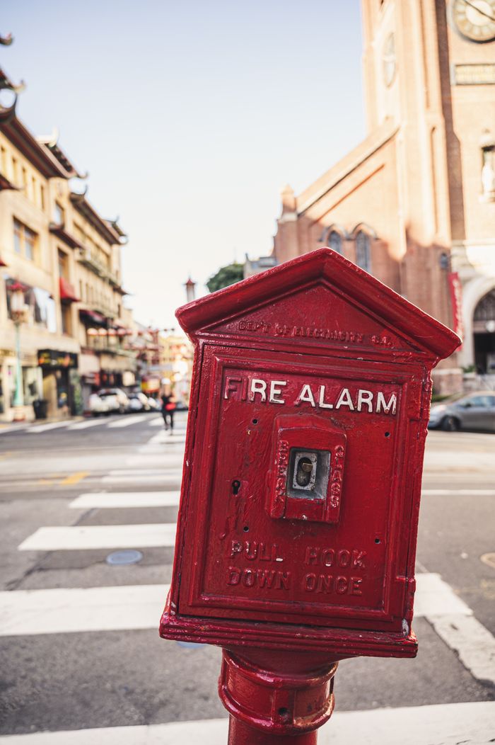 services-img Close-up of a vintage fire alarm in San Francisco's Chinatown, capturing urban street vibe.
